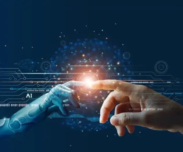 Human hand and robotic hand nearly touch with a glowing core, symbolizing AI and human collaboration in tech.