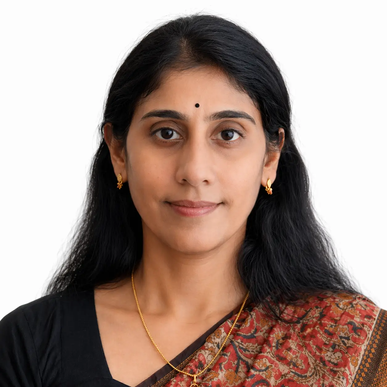 Portrait of an Indian woman with a small black bindi, wearing a patterned sari and gold jewelry, facing the camera.